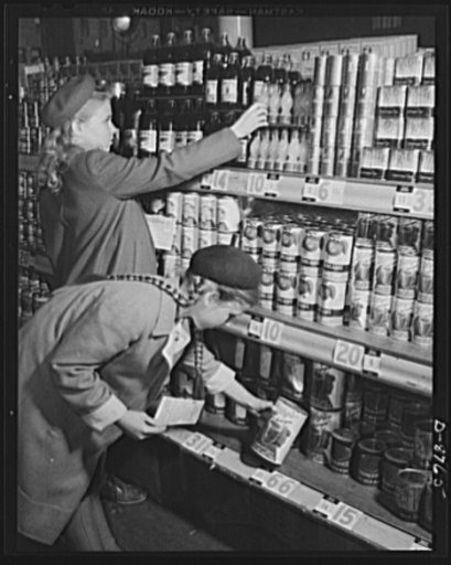 Preparation for point rationing. Never too young to learn, these future homemakers receive first-hand experience in looking for point values as well as prices and information on labels when buying canned and bottled foods with war ration book two