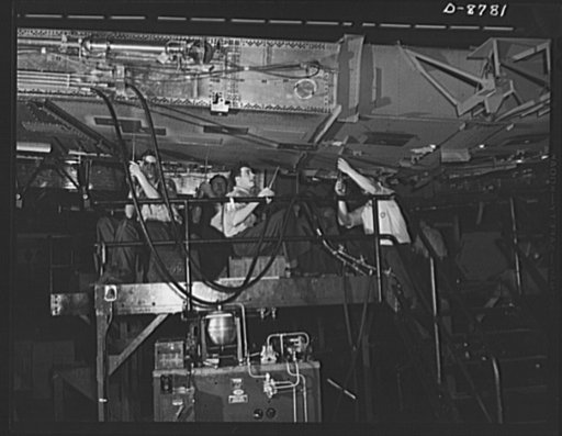 Production. B-24E (Liberator) bombers at Willow Run. Working on a center wing section for a B-24E (Liberator) bomber after it has been placed on one of the assembly lines at Ford's big Willow Run plant. The Liberator is capable of operation at high altitudes and over great ranges on precision bombin