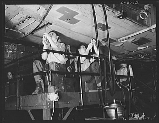 Production. B-24E (Liberator) bombers at Willow Run. Working on a center wing section for a B-24E (Liberator) bomber after it has been placed on one of the assembly lines at Ford's big Willow Run plant. The Liberator is capable of operation at high altitudes and over great ranges on precision bombin