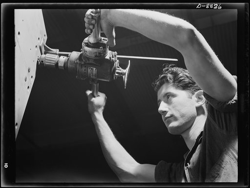 Production. Halftrac armoured cars. Setting machine screws in the body of an armoured halftrac scout car under construction in the plant of a large Eastern manufacturer converted from the making of locks and safes. Diebold Safe and Lock Company, Canton, Ohio