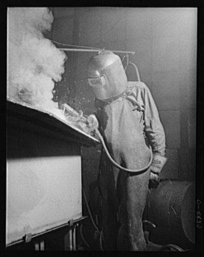 Production. Halftrac armoured cars. An arc welder joins parts of the body of a halftrac scout car in the converted Eastern plant of a lock and safe manufacturer. Diebold Safe and Lock Company, Canton, Ohio