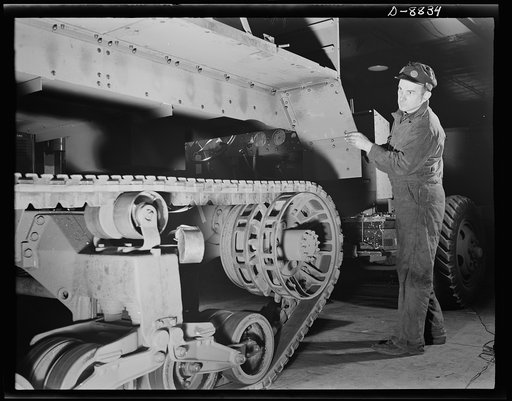Production. Halftrac armoured cars. A partly-finished halftrac scout car body is lowered on a chassis in an Eastern war plant which formerly produced locks and safes. Diebold Safe and Lock Company, Canton, Ohio