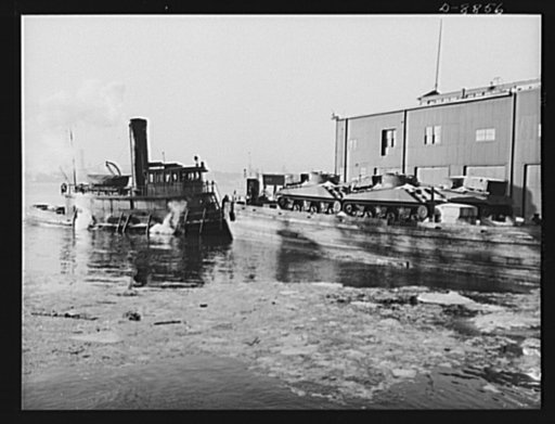 Lend-lease shipments from the United States. American M-4 tanks on a barge alongside a United Nations freighter that will carry them, together with food and other war necessities, as part of a land-lease shipment to one of the Allies
