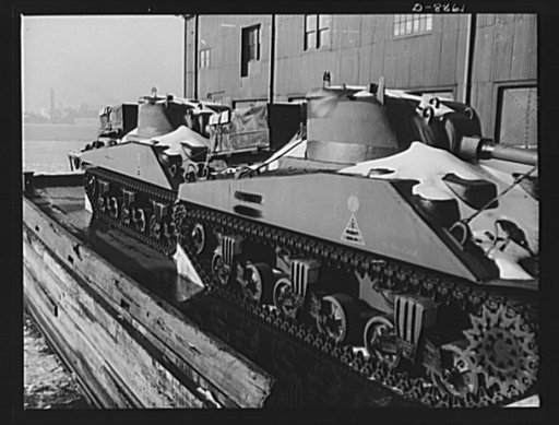 Transportation. Lend-lease shipments. American M-4 tanks on a barge alongside a United Nations freighter that will carry them together with food and other war necessities, as part of a lend-lease shipment to one of our allies