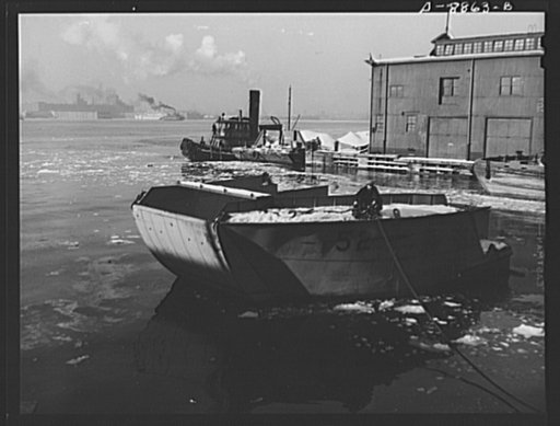 Lend-lease shipments from the United States. This bow section of an American landing barge will be lifted aboard a waiting freighter for shipment to a United Nations battlefront