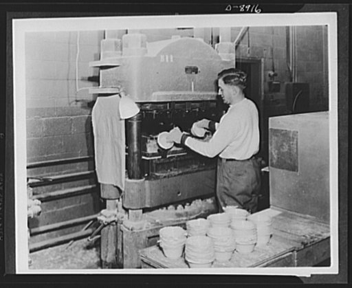 Plastic tableware for the Navy. Plastic bowls that will be used for Navy tableware are removed from the press. The rough edges, called "flash" are later cleaned off