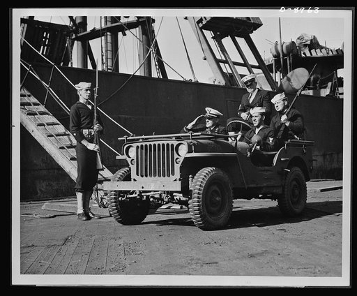 Coast Guard anti-saboteur patrol. A Coast Guard officer is shown at an East coast port with armed Coast Guardsmen in a jeep as he inspects the vigilant waterfront patrols that guard vital war supplies being shipped across. Valuable shipping must be protected on the piers as well as on the shipping l