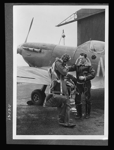 Reciprocal aid. Wearing British flying kits, Lieutenant E.D. Schofield of Belleville, Ohio and Lieutenant R.F. Sargent, of Youngstown, Ohio, prepare to pilot a British Spitfire. Under the Reciprocal Aid Program, Britain is furnishing American air forces important equipment and supplies