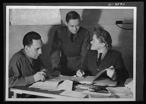 Reciprocal aid. Close cooperation exists between members of the British and U.S. air forces in Britain. Two U.S. sergeants are here shown at work in a coding room with a British WAAF (Women's Auxiliary Air Force) section officer