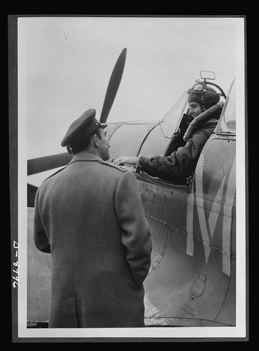 Reciprocal aid. Two gentlemen from Ohio who pilot Spitfire planes in Britain. Lieutenant E.S. Schofield of Belleville, wearing a British flying kit, and R.F. Sargent of Youngstown, wearing a British Irvin jacket, give evidence of the cooperation between British and American air forces. Important equ