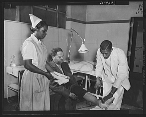 Answering call for volunteer nurses aides. Working always under supervision of a graduate nurse or physician, volunteer nurses aides help out in emergency cases. Photo shows Dr. Granville N. Moore and Miss Florence Grant, volunteer nurses aide, attending a patient in the emergency operating room of 
