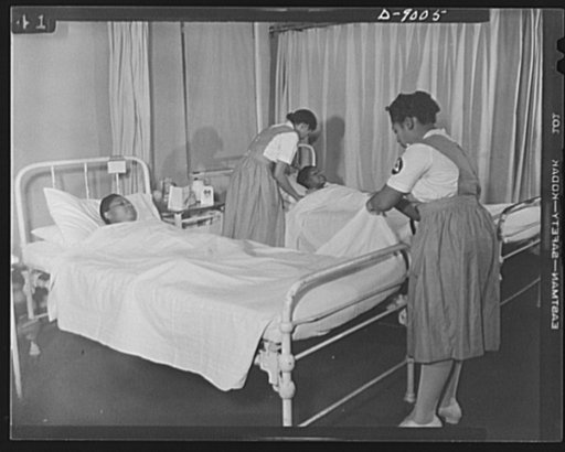Answering call for volunteer nurses aides. Volunteer nurses aides assist graudate nurses by making and changing beds. Photo taken in women's surgical ward of Freedmen's Hospital, Washington, D.C., showing volunteer nurses aide, Miss Romay Johnson (left) and Mrs. Dora Boston (right) changing bedsheet