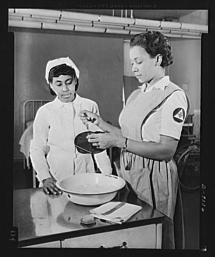 Answering call for volunteer nurses aides. Miss Thelma Harris, instructor of volunteer nurses aides at Freedmen's Hospital, Washington, D.C., gives Miss Maxine Jackson directions on how to fill an ice cap. Miss Jackson is one of the many volunteers now being trained at the hospital