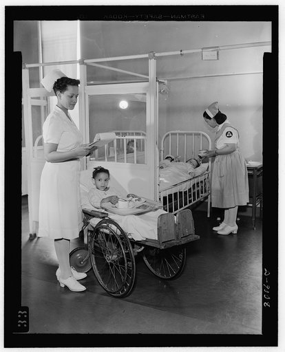 Answering call for volunteer nurses aides. Freedmen's Hospital, Washington, D.C. Senior aide Louise Beleno assists staff nurse Vashti Hall in the care of the patients. Nurse Hall is shown holding food cart, while Aide Beleno feeds another patient