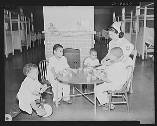 Answering call for volunteer nurses aides. At Freedmen's Hospital, Washington, D.C., senior aide Beleno is shown entertaining four convalescent infant patients. A regular graduate nurse is relieved from this duty