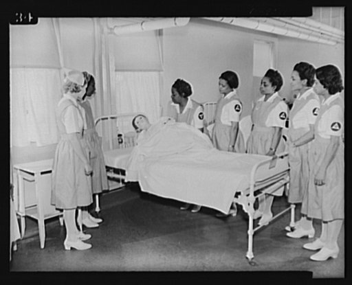 Answering call for volunteer nurses aides. Mrs. George M. Johnson, captain, instructing volunteer nurses aides in the handling of patients at Freedmen's Hospital, Washington, D.C. using "Julius Caesar" as dummy patient. Left to right: Mrs. Johnson, Mrs. Amontha Dawkins, Miss Florence Jackson, Mrs. M