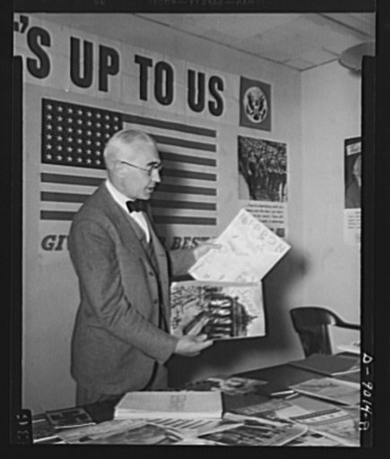 Axis propaganda. Elmer Davis, director of the Office of War Information, examines Nazi and Japanese propaganda organs which he displayed at a press conference on March 6, 1943, to show material the Axis is distributing in neutral countries and the material with which the OWI is fighting it