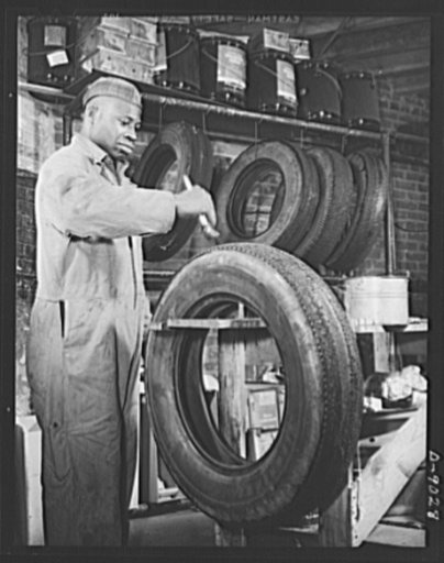 Tire recapping. Preparing a worn automobile tire for recapping. The operator applied a coating of rubber adhesive after the tread surface of the tire has been ground down evenly. The plan to recap passenger tires with reclaimed rubber camelback, approved by rubber director William M. Jeffers, was pu