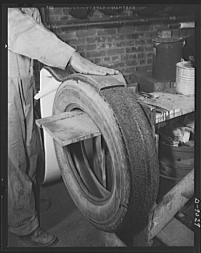 Tire recapping. Recapping a worn passenger car tire. Reclaimed camelback rubber is applied after the old tread surface of the tire has been ground down evenly and coated with rubber adhesive. The plan to recap passenger tires with reclaimed rubber camelback, approved by rubber director William M. Je