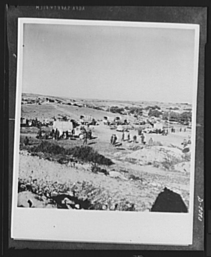 8th Army in Tripoli. The British 8th Army supply column turns aside to avoid a bomb crater, lower left, in the road by Axis planes as a roadblock for the British in the Tripoli campaign