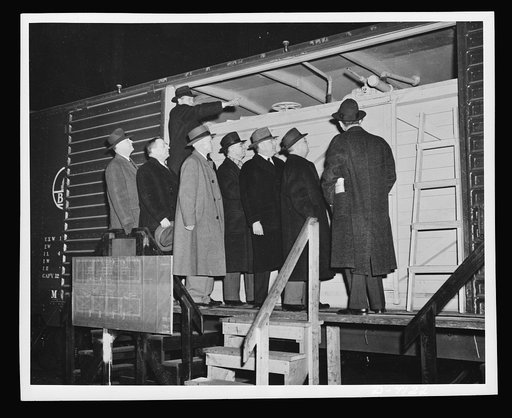 Government and railroad officials inspect the new model boxcar petroleum carrier designed to help the oil shortage in the East. It is estimated by officials of the Office of Defense Transportation that one thousand such cars could add more than 15,000 barrels to the daily receipts of petroleum by ra