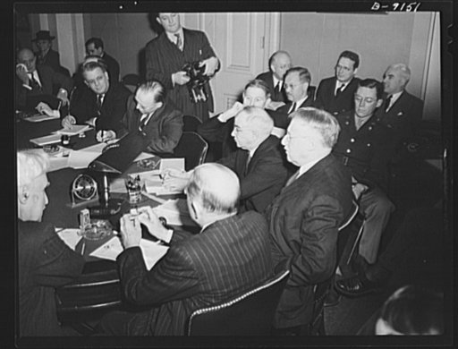 Lend-lease hearings. Secretary of War Henry L. Stimson urges the House Foreign Affairs Committee to recommend continuance of the lend-lease act, as Edward R. Stettinius, Jr., lend-lease administrator (in the background to the right) listens. The committee later recommended it