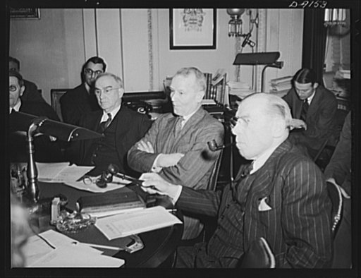 Lend-lease hearings. War Shipping Administrator Emory S. Land, ponders a question of a member of the House Foreign Affairs Committee on the value of the lend-lease act to the war effort, at a hearing in Washington. The committee later recommended that the act be continued in effect. Representative S