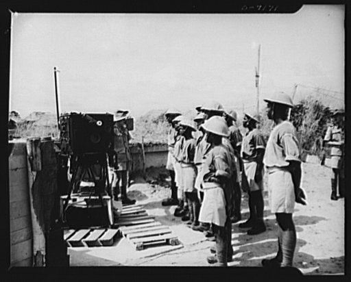 African natives prepare for air attack. Guarding against possible enemy attacks in Africa, crack veterans of the Battle of Britain are instructing African natives in anti-aircraft units. New African recruits listen attentively as the instructor, a British artilleryman, explains the operation of a ra