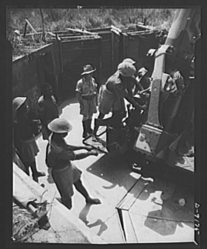 African natives prepare for air attack. Guarding against possible enemy attacks in Africa, crack veterans of the Battle of Britain are instructing African natives in anti-aircraft units. With an Allied plane as the target, the natives receive actual combat practice by firing directly at the plane ra