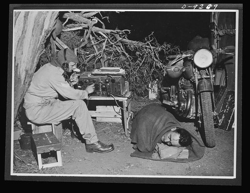 Australia in the war. Australian dispatch riders at unit headquarters sleep beside their American motor, ready to take messages at any hour of the day or night