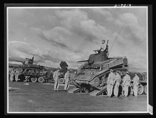 Australia in the war. Australian troops demonstrate lend-lease tanks at an armored division camp somewhere in Australia. Tanks are transported on trucks to save wear and tear on the fighting vehicles