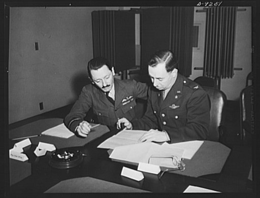 Combined Munitions Assignments Board. Staff members of the Combined Munitions Assignments Board compare data at weekly meeting of the board in Washington. Left to right are: Air Commander H.T. Lydford (British) and Colonel E.C. Langmead (American)
