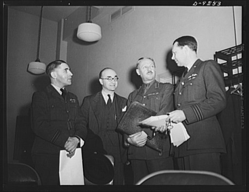 Combined Munitions Assignments Board. Staff members of the Combined Munitions Assignments Board discuss military matters at weekly meetings in Washington. Left to right are: Lieutenant M.V. Stewart (British); Mr. E.A. Seal (American); Brigadier L.F.S. Dawes (British); and Wing Commander T.E.H. Birle