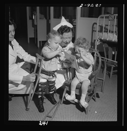 Nurse training. A nurse and the physical therapist negotiate something of a dispute over a picture book between two young patients in an orthopedic hospital