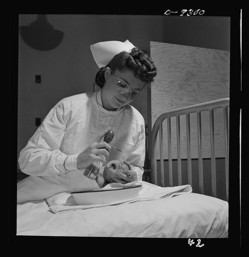 Nurse training. Care of infants is included in all nurses training. This youngster is about to get an eye irrigation. Note that nurse wears goggles for self-protection from possible infection