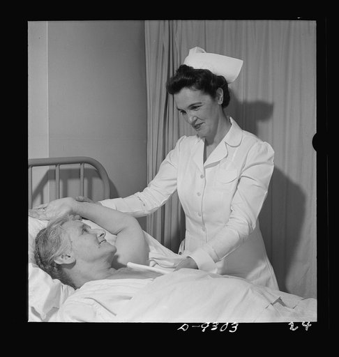 Nurse training. Post-operative care of patients is part of every nurse's responsibility. This nurse is showing a patient, recovering from a mastectomy, how to exercise her arm properly