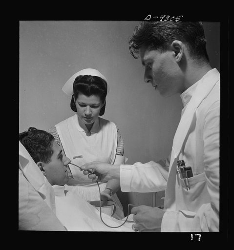 Nurse training. A student nurse aides the doctor in a gastric analysis