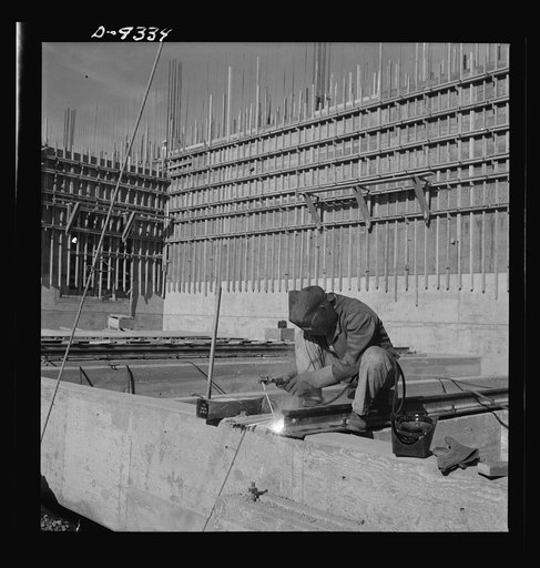 Production. Magnesium. A helmeted welder is busily engaged in his part of the war effort at Basic Magnesium's huge plant in the southern Nevada desert. The plant is turning out great quantities of magnesium for aircraft and tracer bullet manufacturers