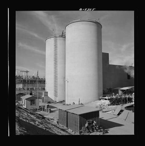 Production. Magnesium. Giant silos for the storage of raw materials for the manufacture of magnesium tower eighty-four feet on the southern Nevada desert. They are part of the huge Basic Magnesium plant near Las Vegas