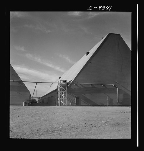 Production. Magnesium. Like a scene in the Egyptian desert is the preparation area of Basic Magnesium's giant plant now nearing completion in the southern Nevada desert. The pyramidal form of 540 x 100-foot peat storage buildings is reminiscent of the Nile country