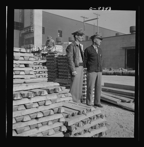 Production. Magnesium. Two men of the plant protection force guard the stacks of vital magnesium produced at Basic Magnesium's giant plant in the southern Nevada desert. This lightest of all metals is used in the making of incendiary bombs, tracer bullets and aircraft parts