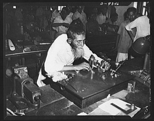 Mohamed Ellai Buksh, sixty-two, works with lend-lease precision tools in India's oldest munitions factory. Ellai Buksh has been at his job in this plant for almot thirty years and of his thirteen children six sons are working either in this munitions plant or others