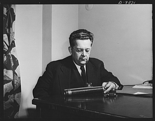 War workers' ideas that save man-hours and critical materials are evaluated by a board of experts, whose chairman is Ray Millholland of Indianapolis, engineer and author, here shown examining working models submitted by War Production Drive headquarters in Washington. Twelve engineers and technical 