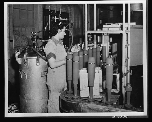 Production. Shell loading. On the "firing line" of a large Midwest loading plant, artillery shells soon to batter the Axis are sprayed with olive drab paint. This women is a sprayer, but women also do the "puddling" of TNT in shells better than men. For "puddling," the stirring and packing of TNT in