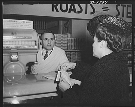 Meat rationing preview. Food editor of a woman's magazine shops for meat with red stamps. The "butcher" is William Nielander, Office of Price Administration (OPA) rationing executive