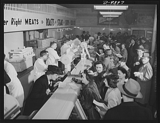 Meat rationing preview. Reporters make their own news. Washington correspondents get preview of meat rationing in operation with Office of Price Administration officials behind counter. In left foreground is Mrs. Philip Crowlie, OPA's "typical housewife," explaining the system to a woman reporter, w