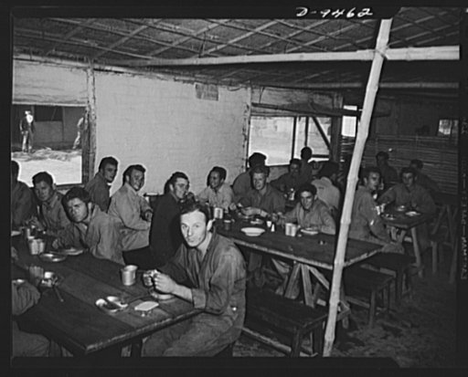 An American flying squadron in India. Chow time. While it's not the Astor it serves just as well for the food is good and second servings can be had. Most buildings in this camp were constructed by local labor but our boys have taken part in later construction, having learned many forms of handicraf