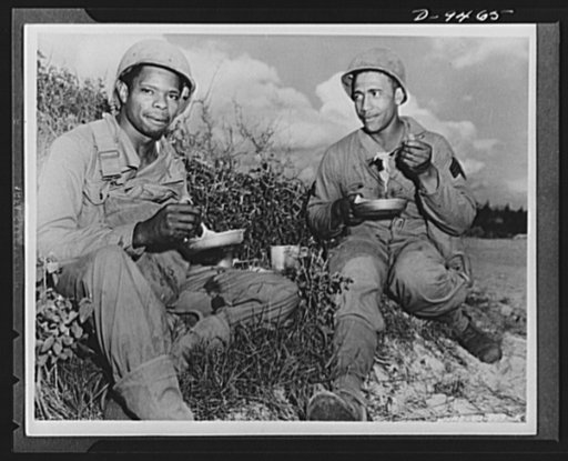 With an airfield security detachment in Hawaii. Private William Jackson, Oxford, Alabama and Sergeant William Flowers, La Grange, Georgia, members of an airfield security detachment in Hawaii, take chow in the field during maneuvers