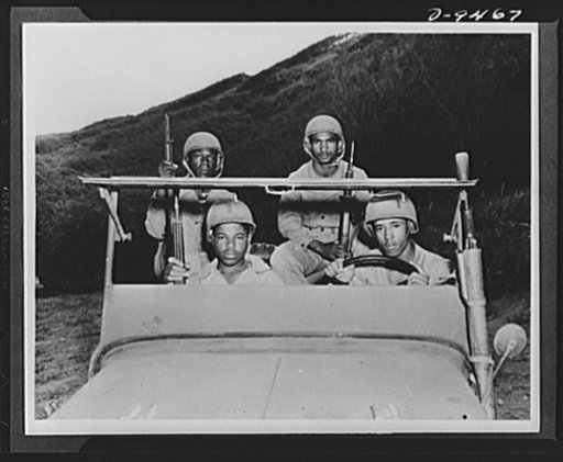 With an airfield security detachment in Hawaii. Four men in a jeep at the Dusty Hollow Training Center included the following members of an airfield security detachment in Hawaii. Front seat (left to right): Private Lester H. Howell, Statesville, North Carolina and Private First Class Thomas Irvin, 