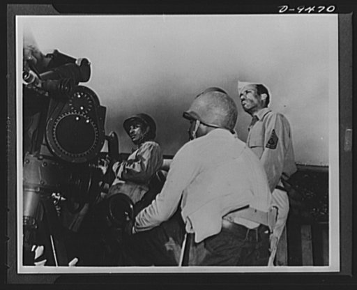 With an airfield security detachment in Hawaii. First Sergeant Vancito Stephens, New York City; Private Alonzo Dantzler of Cedarville, New Jersey and Corporal Glenville Riley, Brooklyn, New York watch the operation of intricate anti-aircraft machinery at their post with an airfield security detachme
